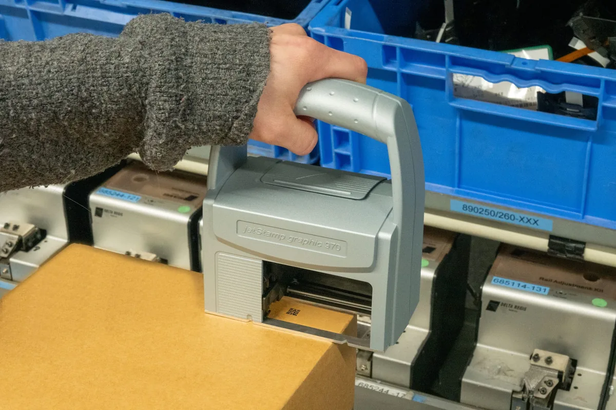 REINER jetStamp graphic 970 printing on a carton in a crate